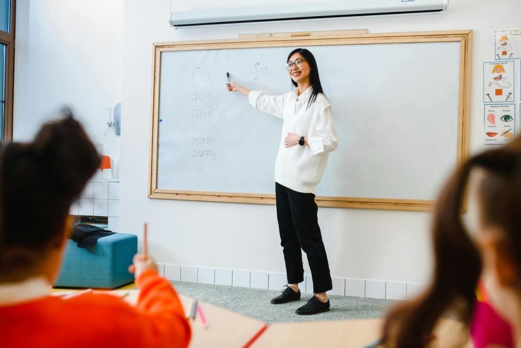 Teacher teaching student kids in a classroom