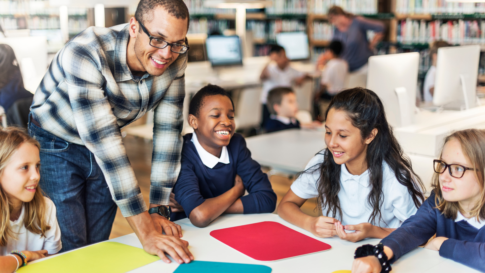 teacher with 4 students in the table smiling